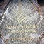 Logo "WILHELM WELHAUSEN" en el interior de una gorra
